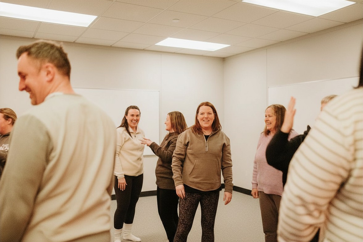 Employees moving and connecting during a corporate wellbeing workshop in Glasgow.