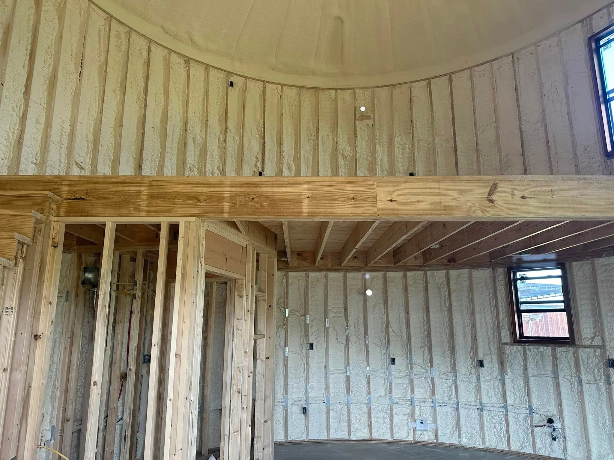 Open cell spray foam insulation in residential room for energy efficiency, soundproofing, and air sealing