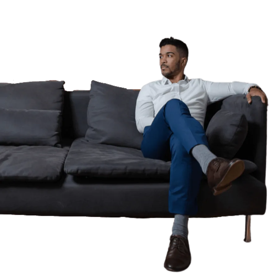 Ralph seated on a dark sofa, looking to one side