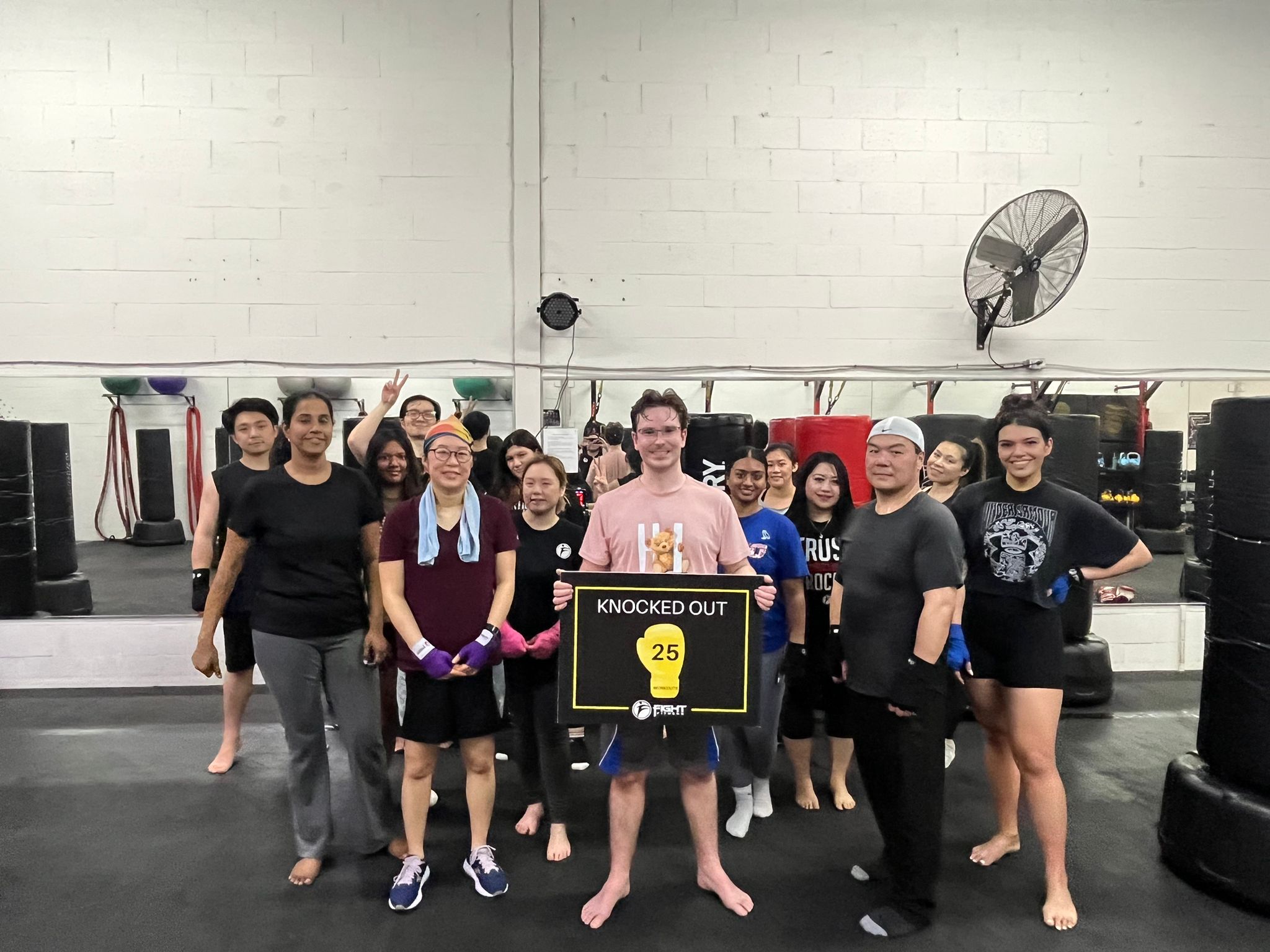 Mac holding his 25-class milestone board at Fight Fitness kickboxing gym in Markham after building consistency, confidence, and healthier fitness habits. Mac holding his 25-class milestone board at Fight Fitness kickboxing gym in Markham after building consistency, confidence, and healthier fitness habits.