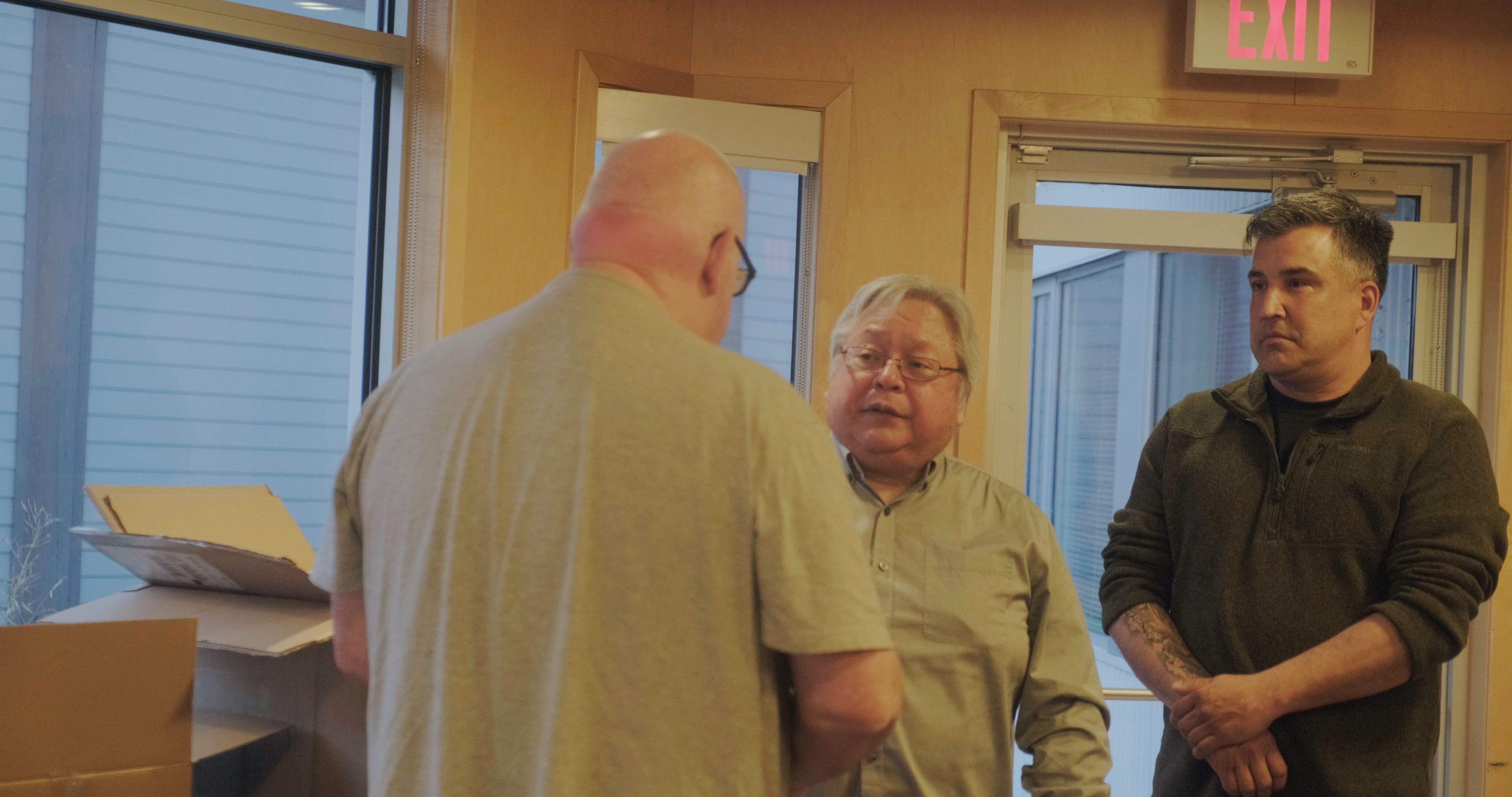 Two men greeting each other in a doorway