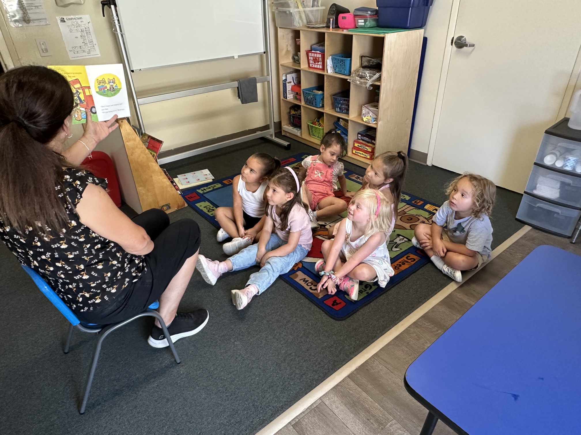 Teacher interacting one-on-one with a toddler at Creative Years Preschool, warm expression, natural daylight