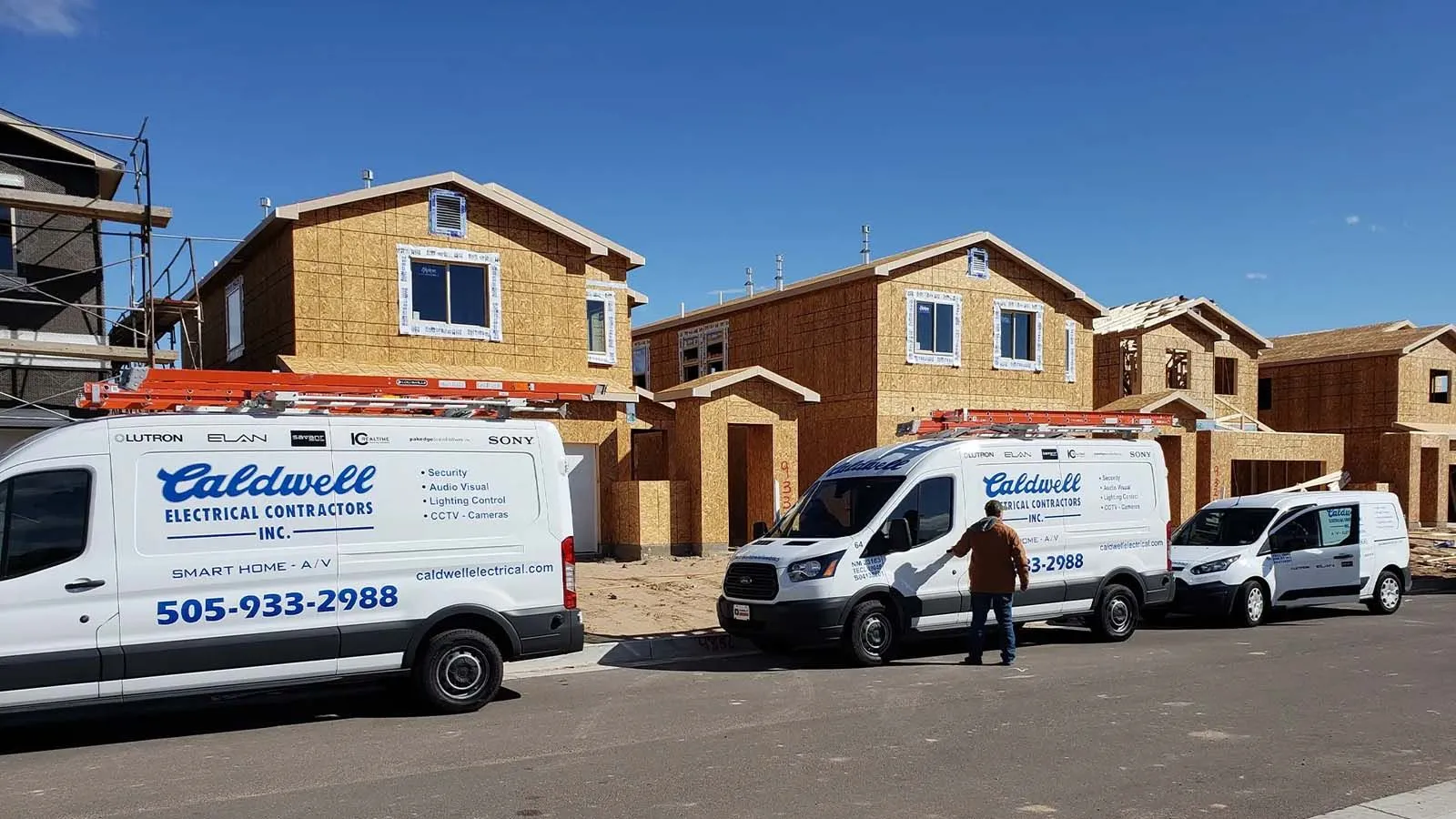 Caldwell Electrical service vans parked at residential construction site for new wiring and electrical installation in New Mexico