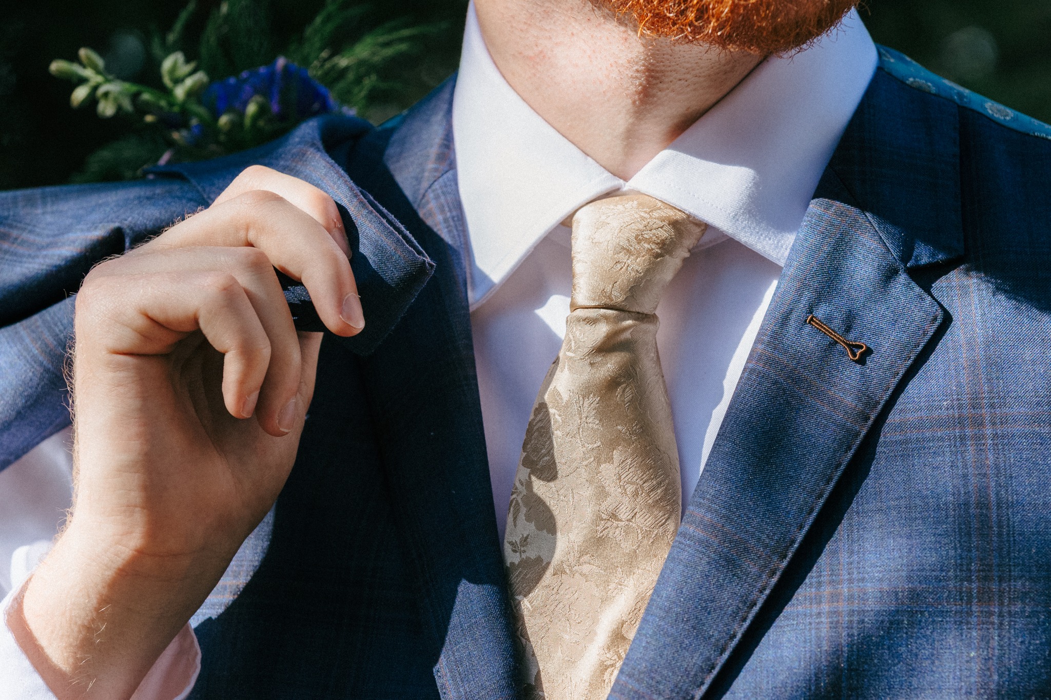 Close-up of a tailored blue suit and gold tie