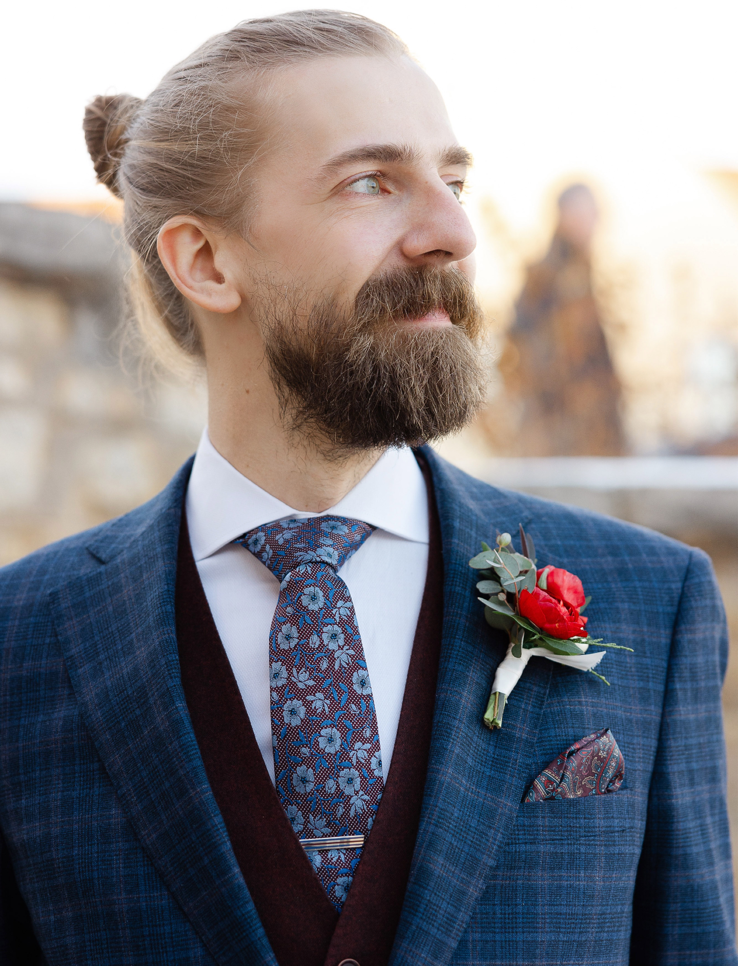 Groom in a plaid suit with a red boutonniere