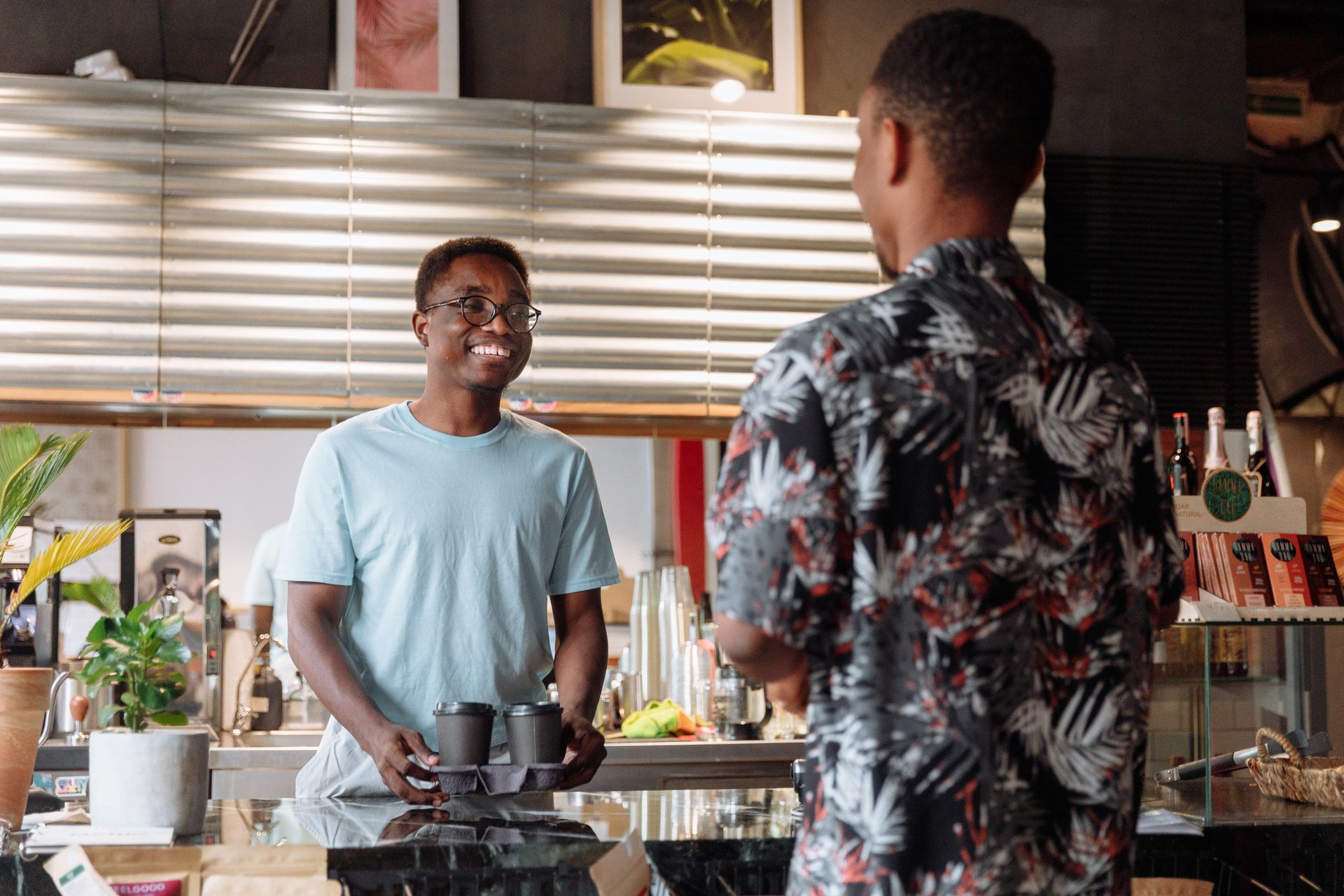 Barista handing coffees to a customer