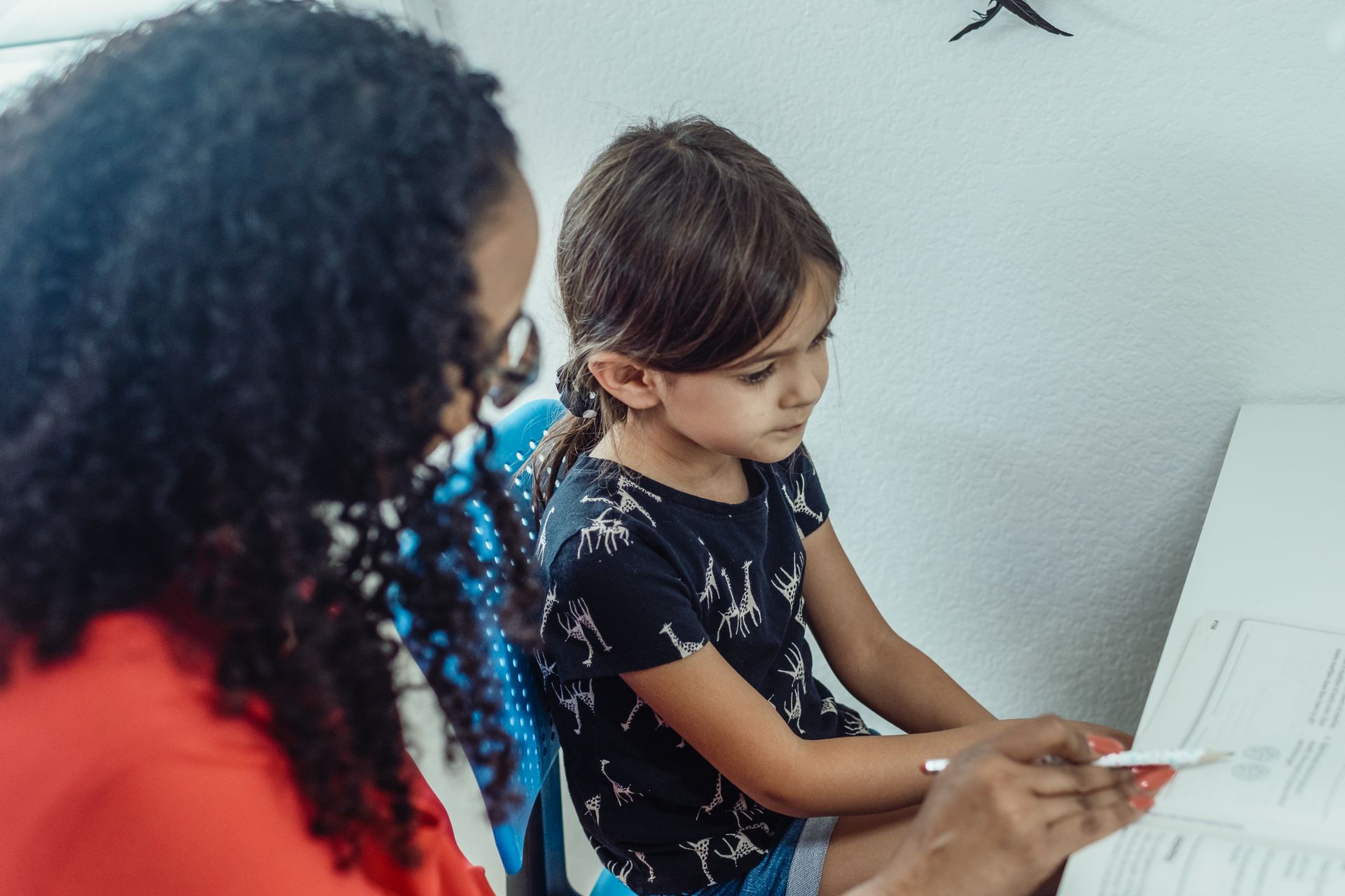 Tutor helping a young student with a workbook