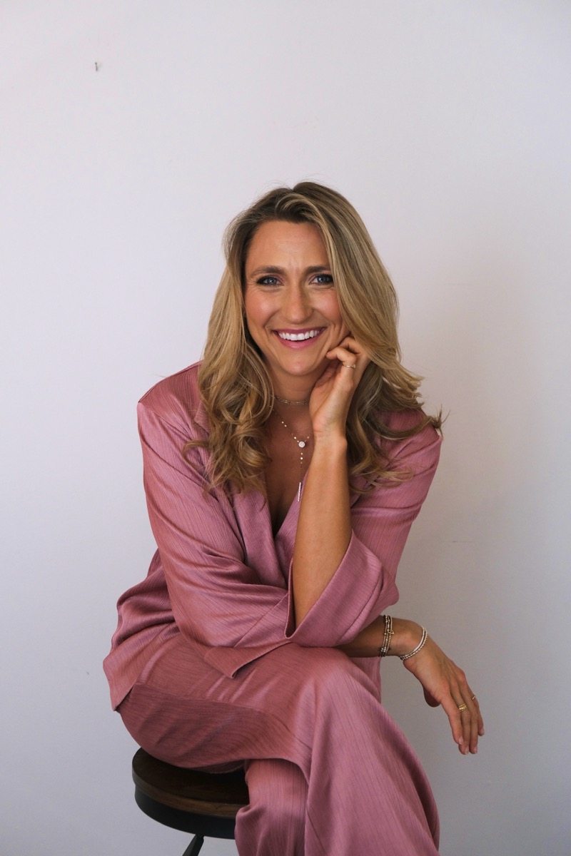 Dallas Cole smiling, seated in a blush suit