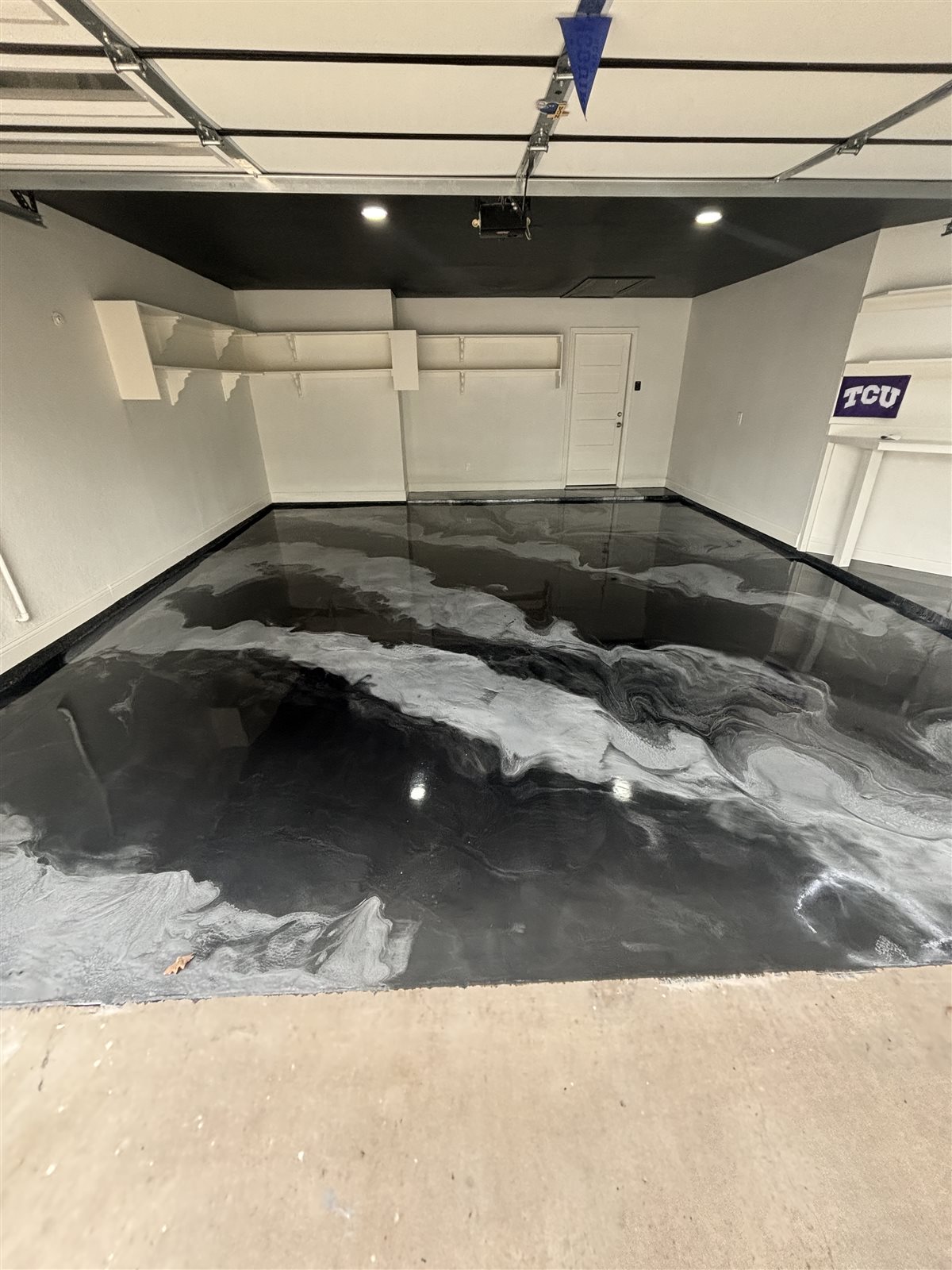 Black and white metallic epoxy garage floor in a Burleson, TX home