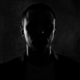 Tattoo artist wearing a cap and black shirt, showcasing expertise in body art at GameFace Tattoos studio in Orlando.