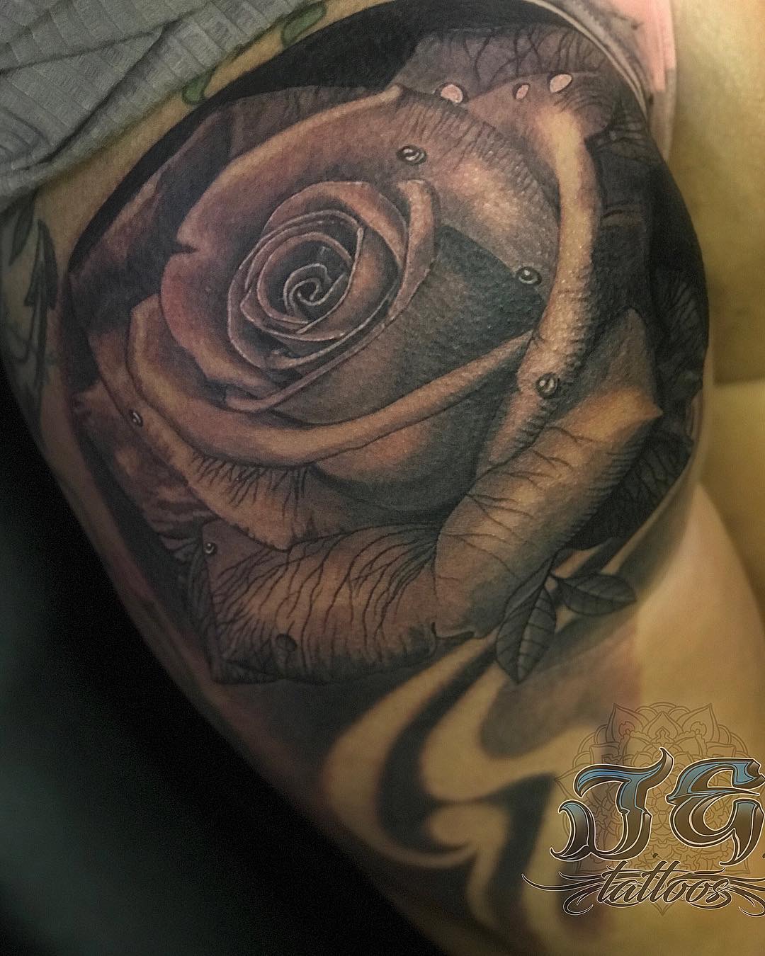 Detailed black and gray rose tattoo with water droplets, showcasing artistry by Jest Estevez at GameFace Tattoos.