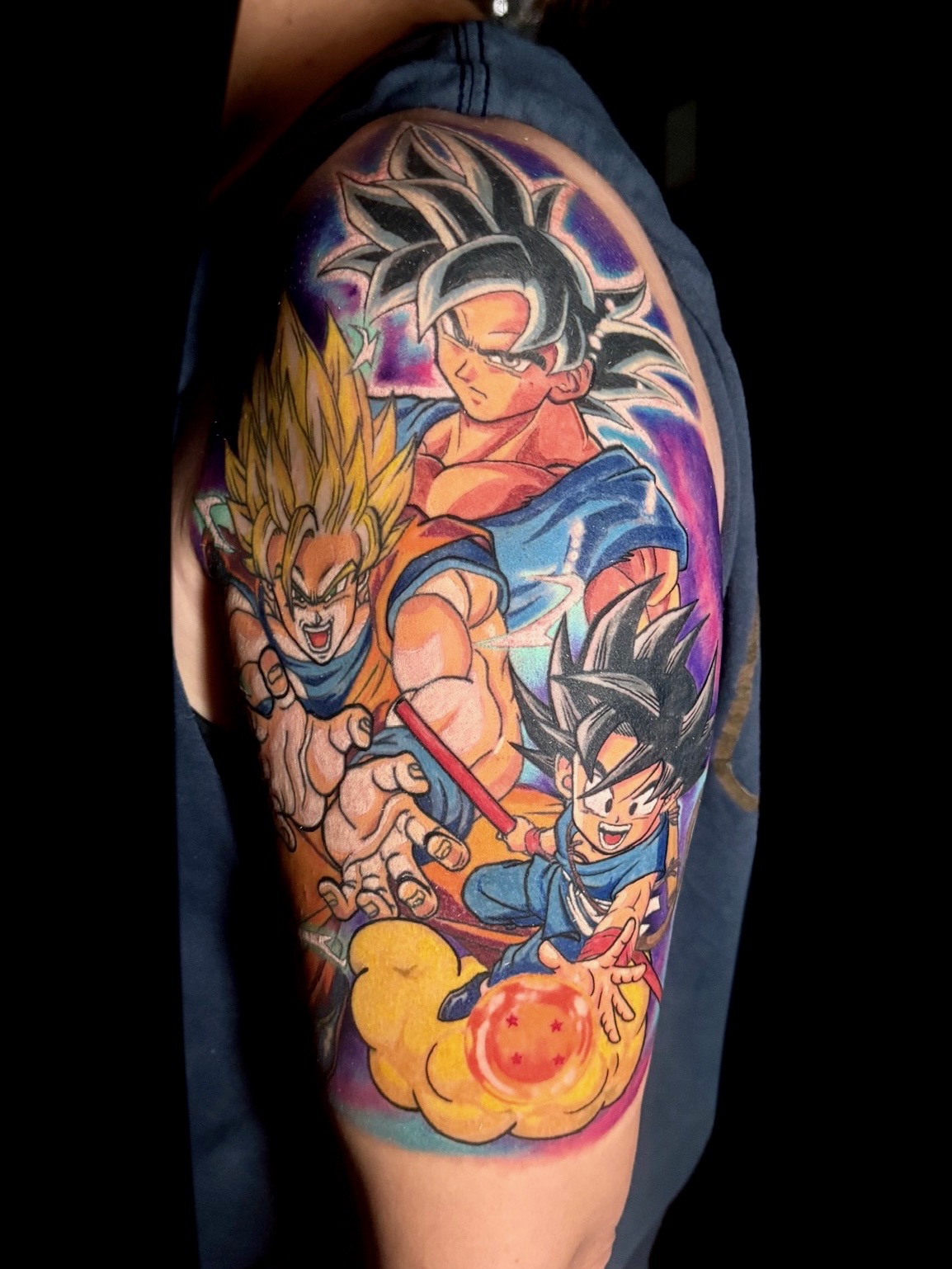 Colorful tattoo featuring iconic Dragon Ball characters Goku, Gohan, and Goten in dynamic poses, showcasing vibrant artistry and personal expression.