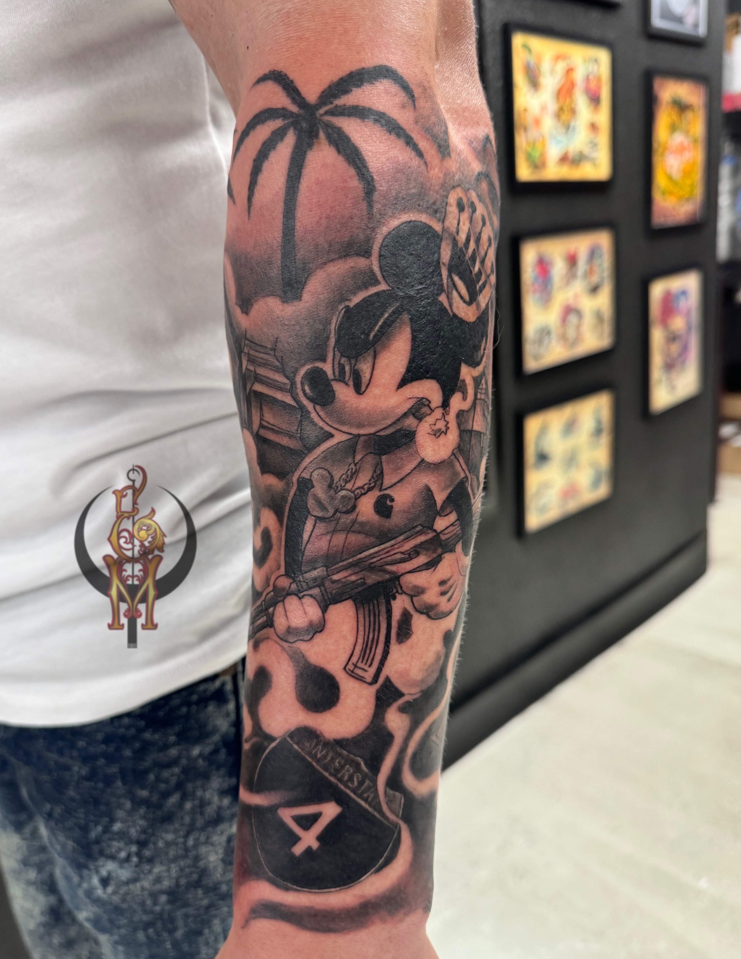 Tattoo of Mickey Mouse holding a skateboard and wearing accessories, surrounded by palm trees and stylized smoke, showcasing Edward Madera's artistry at GameFace Tattoo.