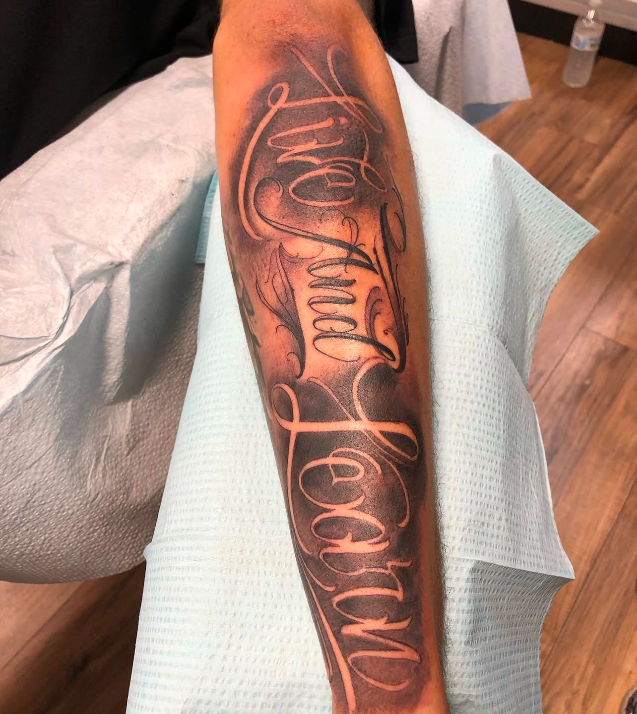 Tattoo on forearm featuring the phrase "Live And Learn" in elegant script, showcasing Edward Madera's artistry and custom design work at GameFace Tattoo.