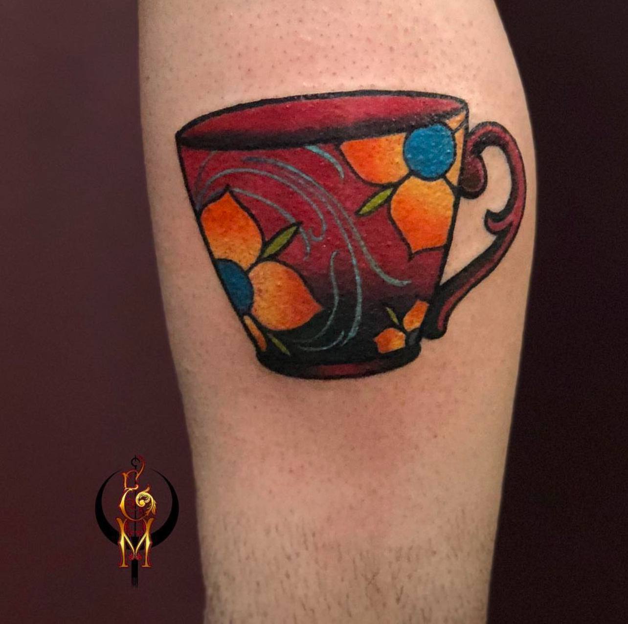 Colorful floral tattoo of a teacup on a forearm, showcasing Edward Madera's artistic style and custom design expertise at GameFace Tattoo.