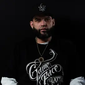 Master artist from GameFace Tattoos wearing branded apparel, showcasing body art expertise in a studio setting.