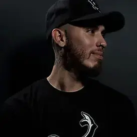 Tattoo artist wearing a cap and black shirt, showcasing expertise in body art at GameFace Tattoos studio in Orlando.