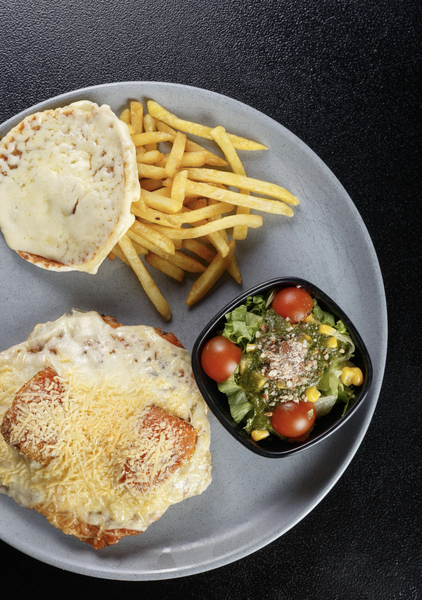 Matambrito de cerdo gratinado con queso fundido y papas fritas