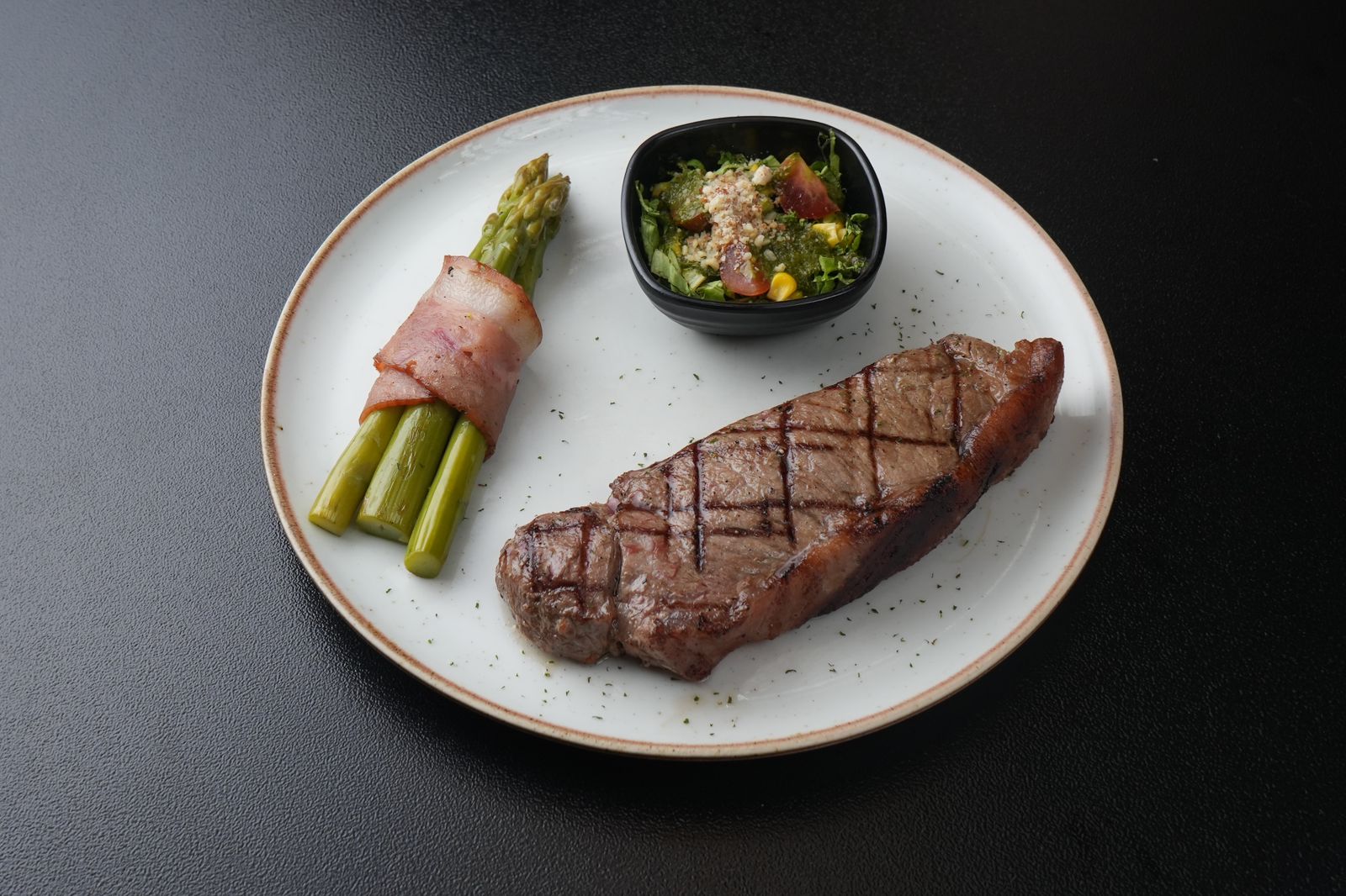 Corte New York Angus 350gr a la parrilla con espárragos envueltos en tocineta