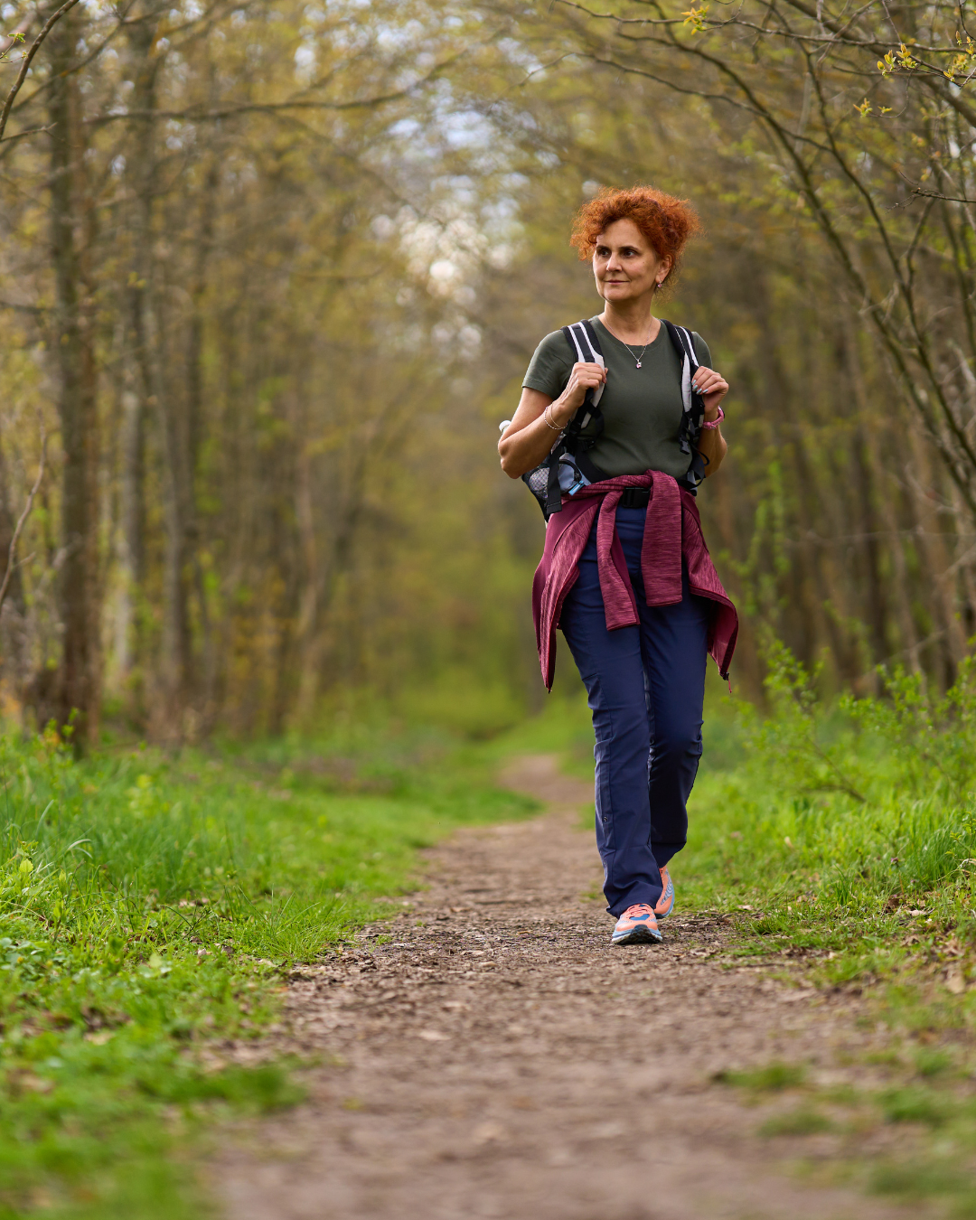 Une femme rousse prend une marche en forêt