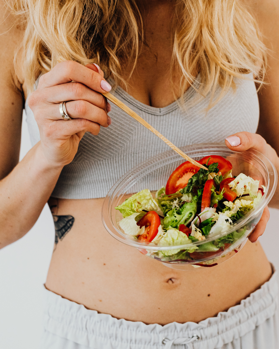 Une femme mange une salade