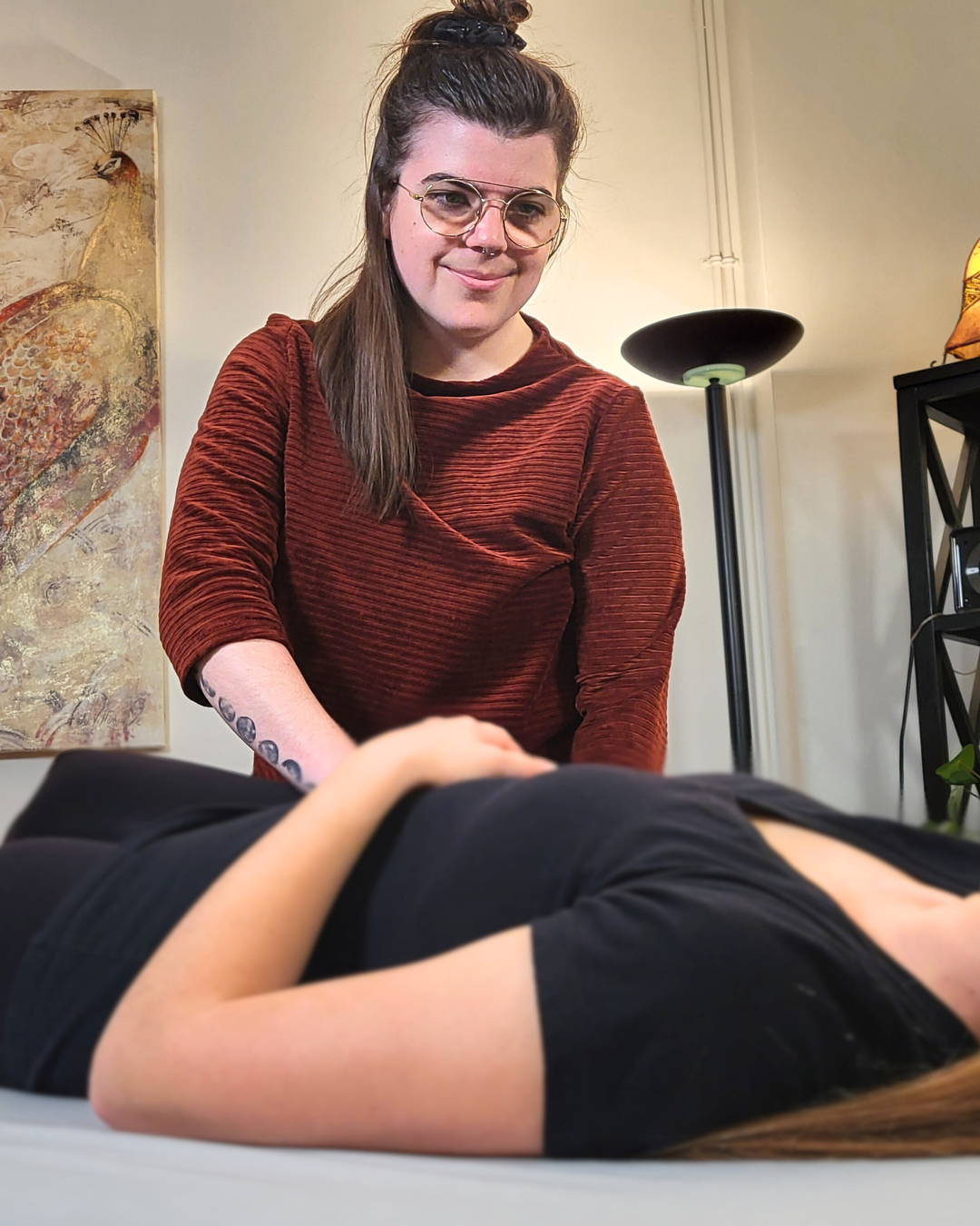 Une femme debout traite une femme couchée