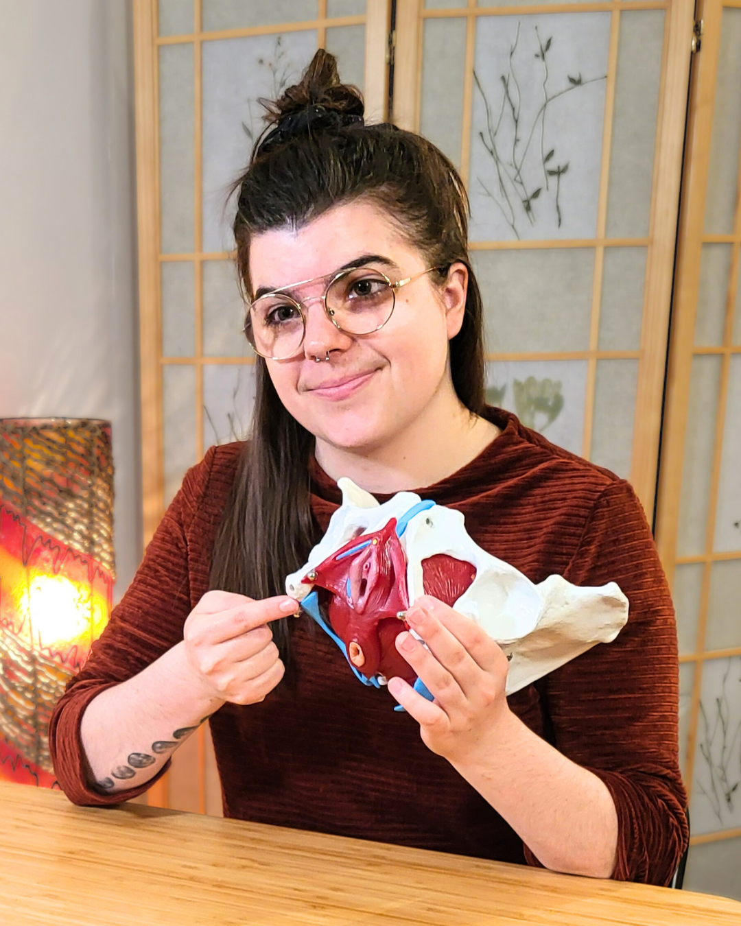 Une femme pointe un modèle anatomique de plancher pelvien