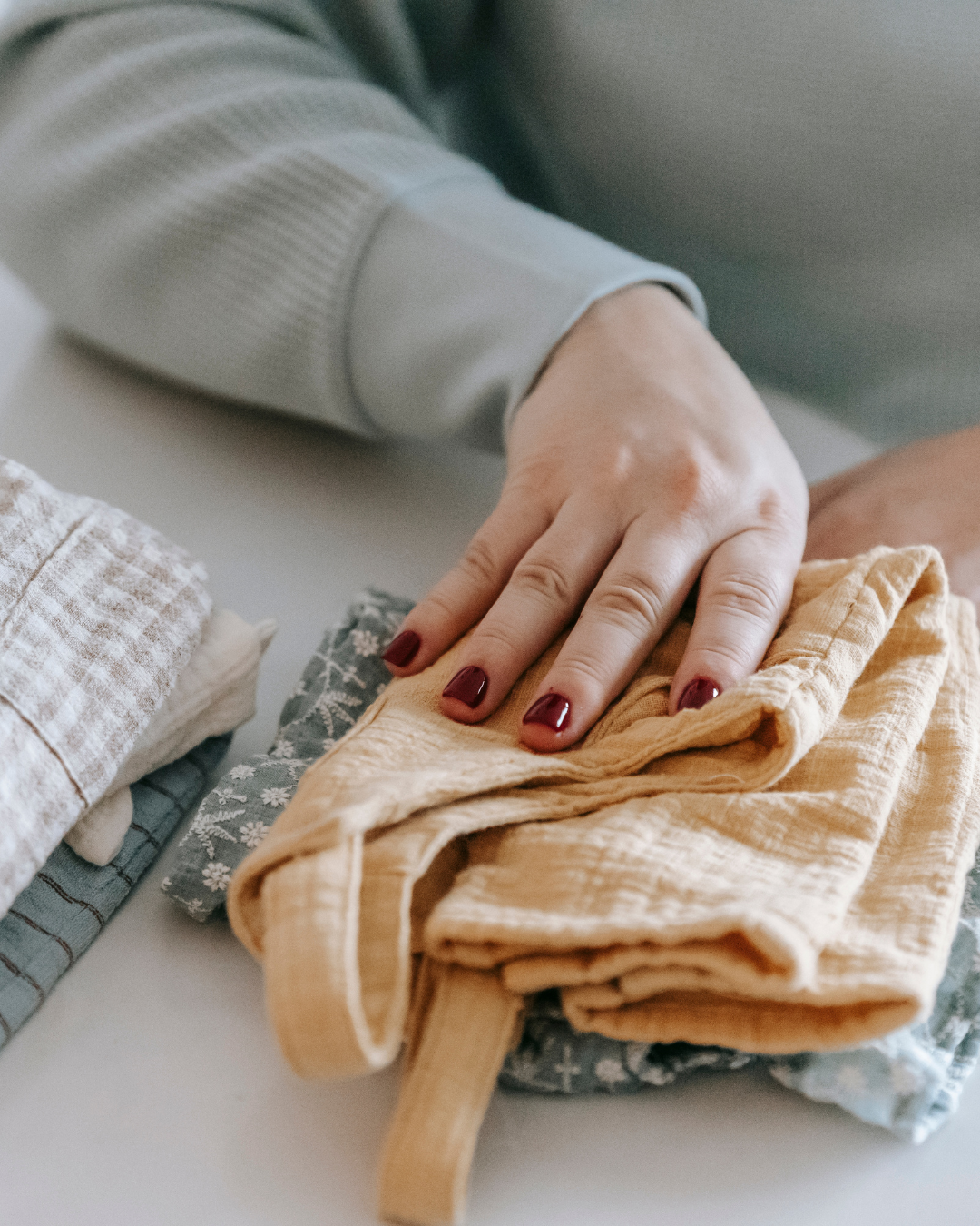Une main de femme prend un morceau de vêtement