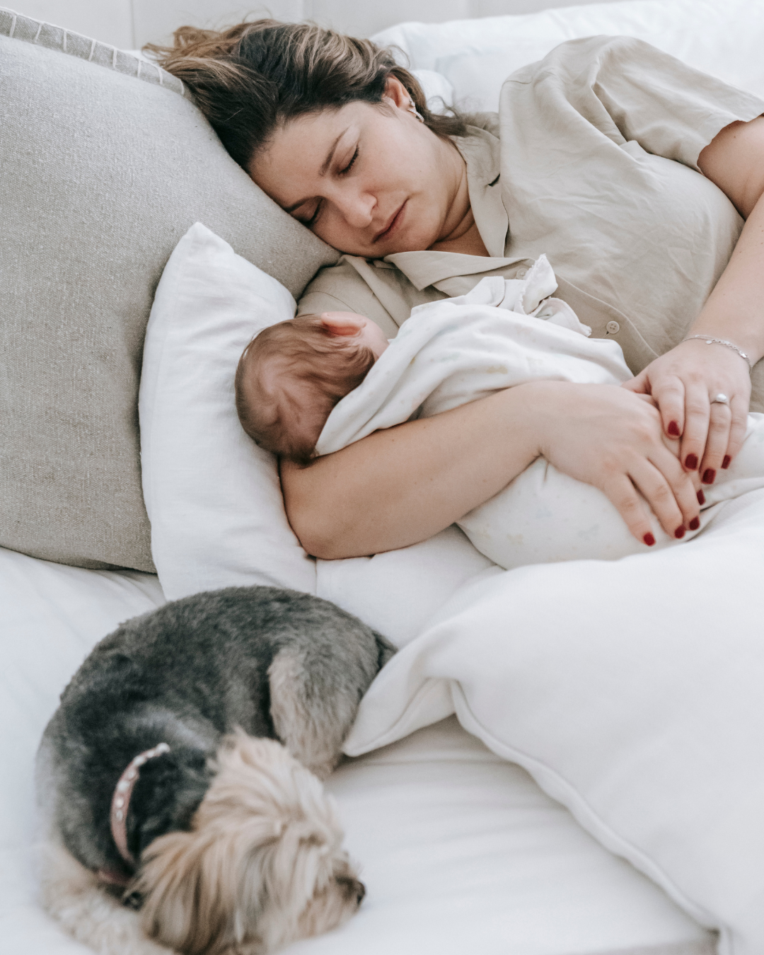 Une femme dort avec son bébé et son chien