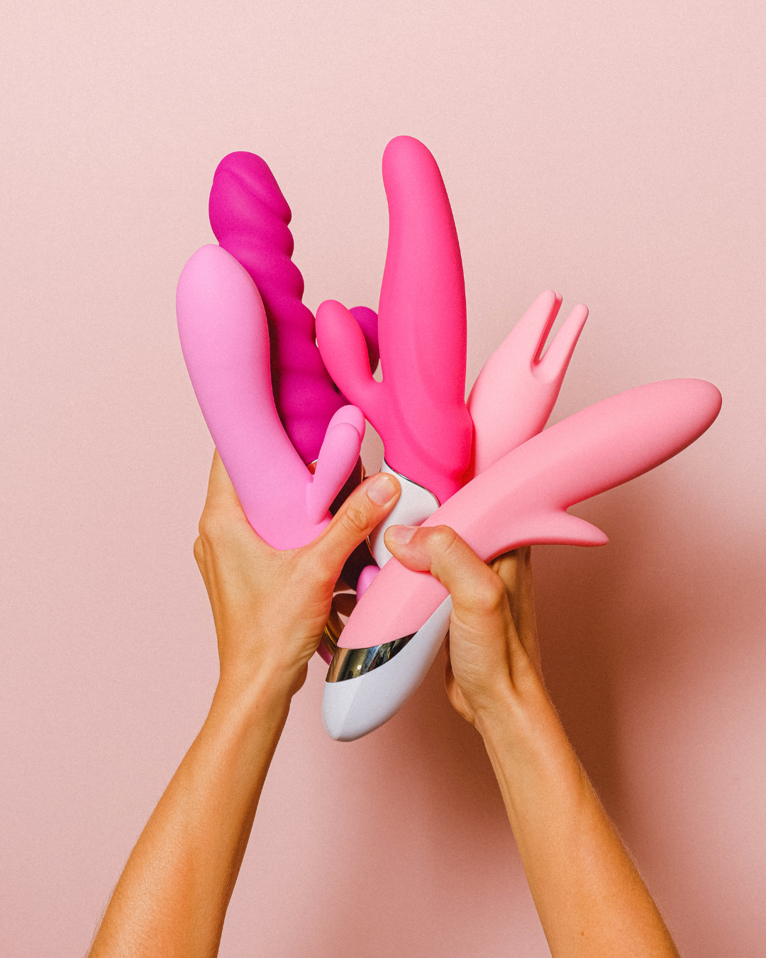 Une main de femme tient des jouets sexuels