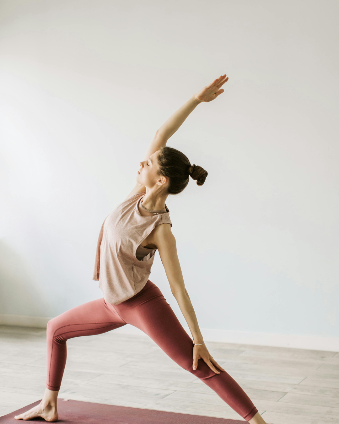 Femme qui fait la posture de yoga du guerrier inversé Femme qui fait la posture de yoga du guerrier inversé