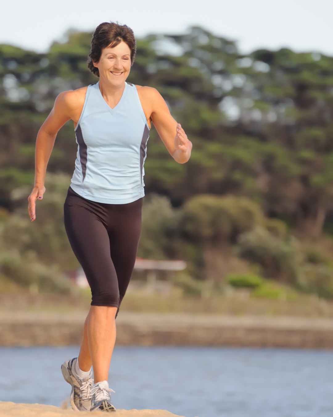 Femme d'une cinquantaine d'années qui fait du jogging à l'extérieur Femme d'une cinquantaine d'années qui fait du jogging à l'extérieur