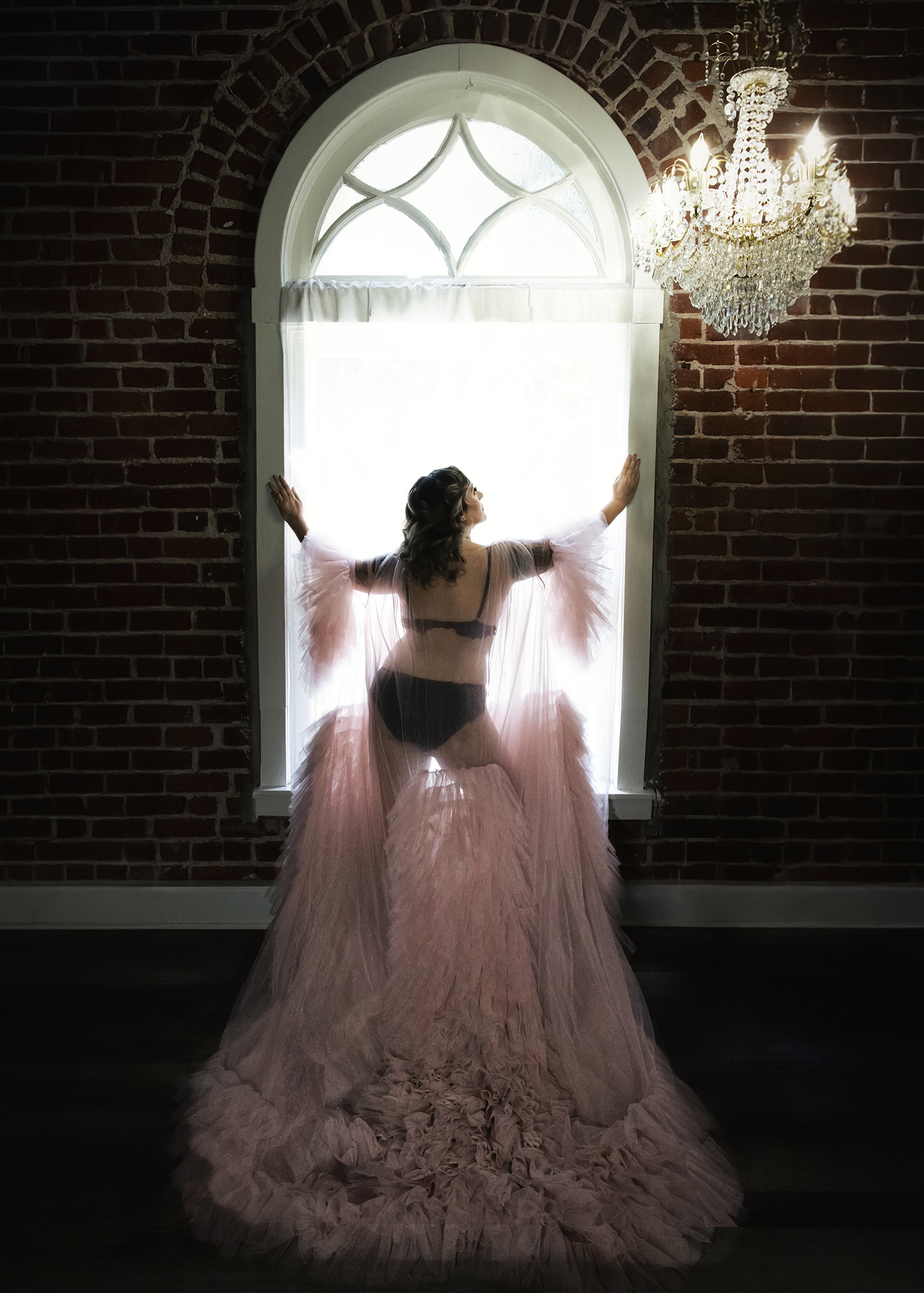 boudoir pink robe with window back light brick wall Barb Hauser Photography