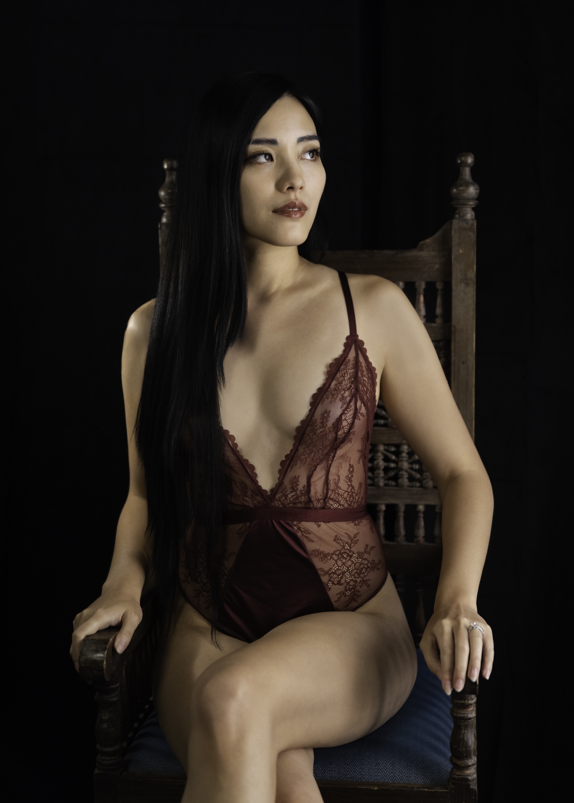 boudoir woman in chair with long black hair by Barb Hauser Photography