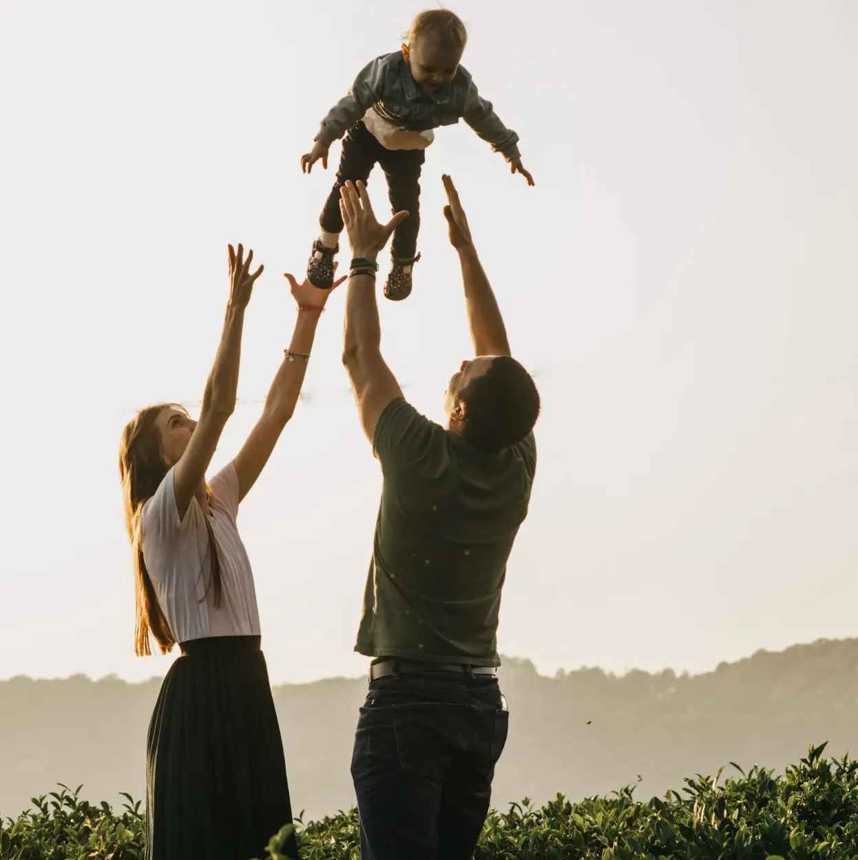 Parents lifting their child into the air