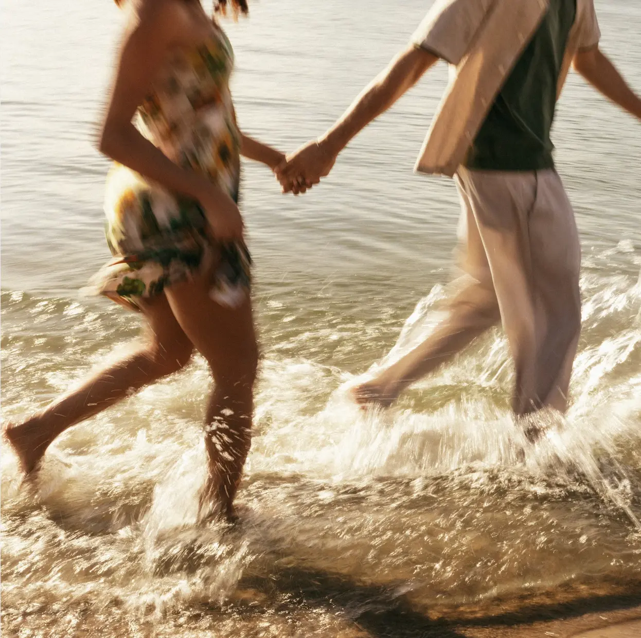 Couple walking hand in hand along the beach
