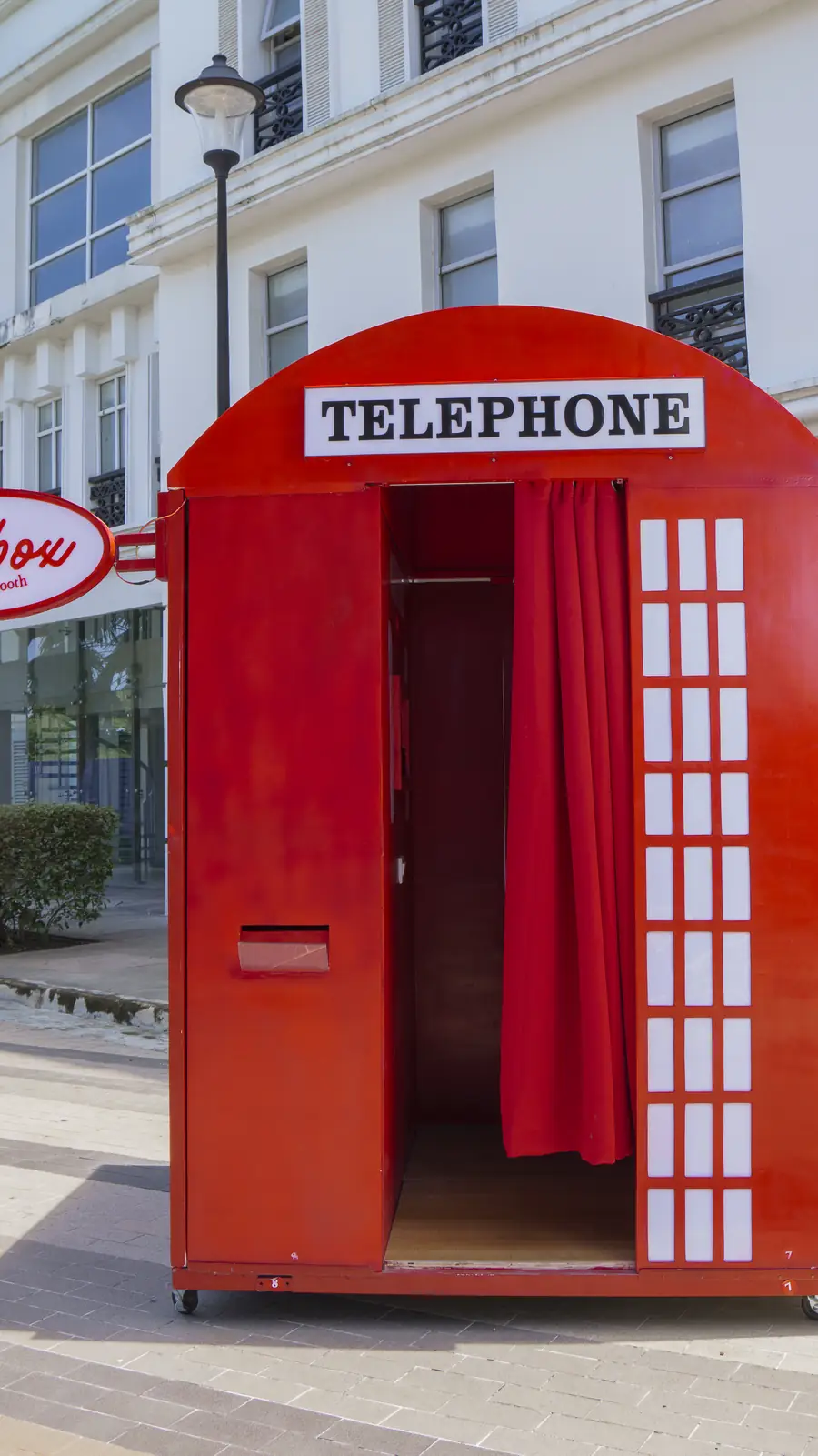 The Dialbox booth from the front: red panels, white window grid and the TELEPHONE sign