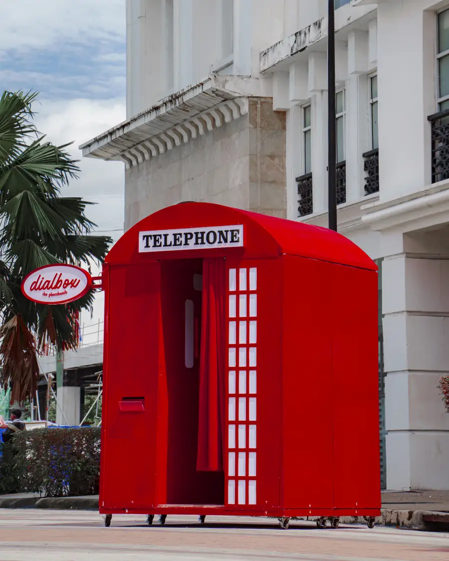 The empty Dialbox booth beside a palm tree