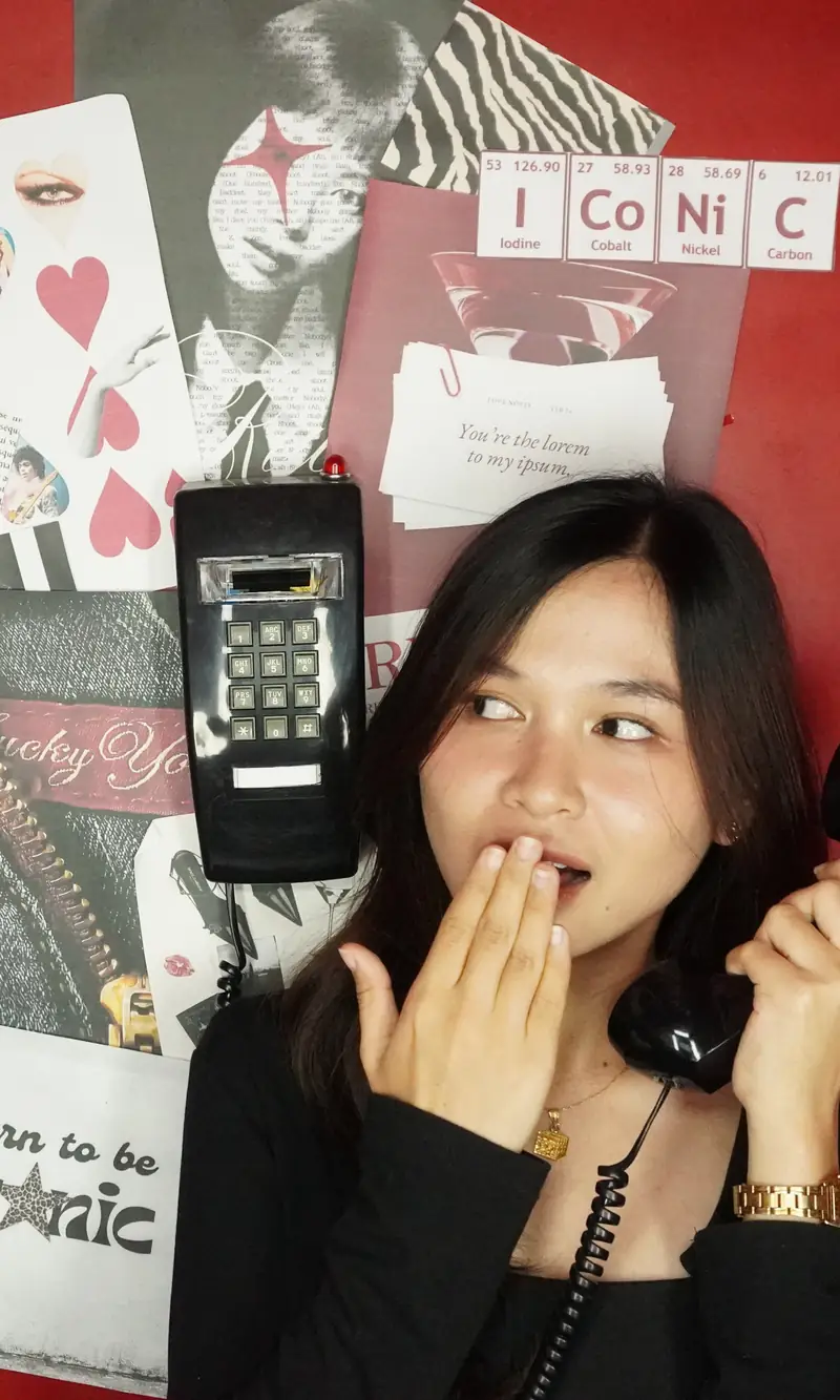 A guest on the booth phone, hand over her mouth, at Big House