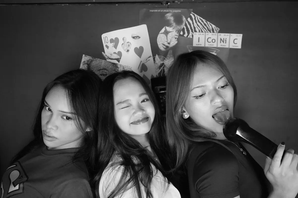 Three friends in black and white, one singing into the phone, at Big House
