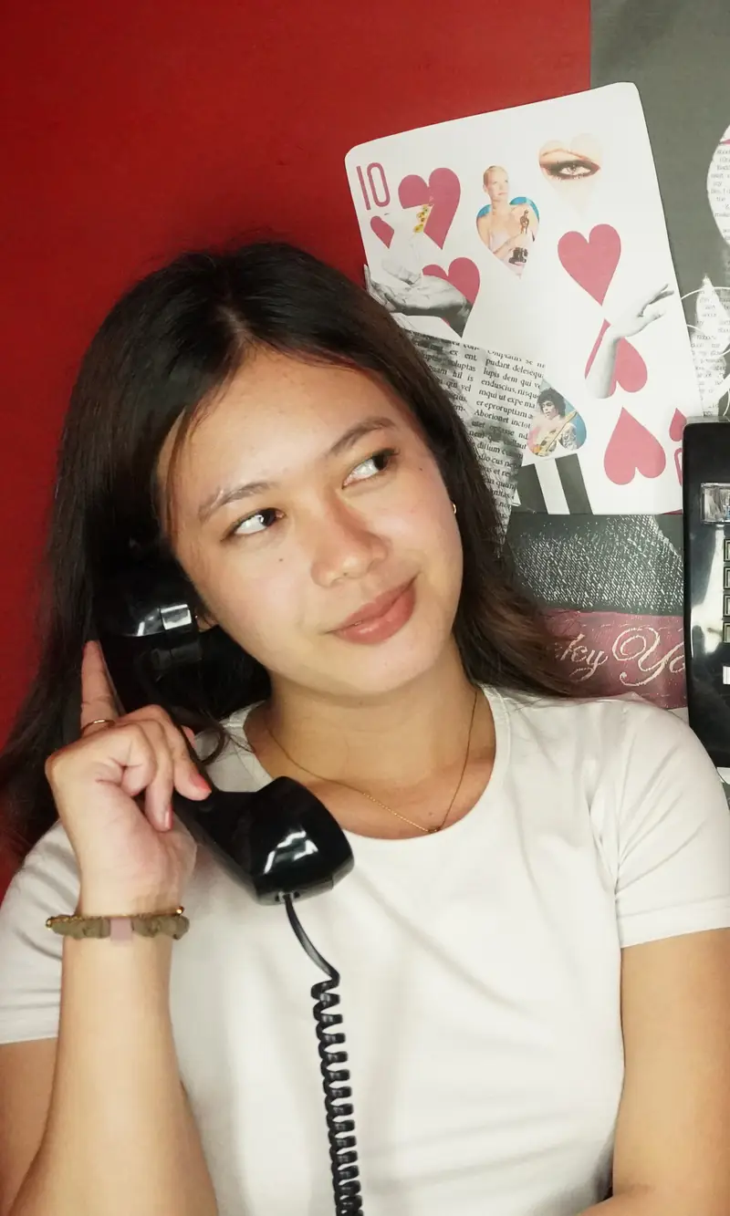 A guest on the booth phone against the red wall at Big House