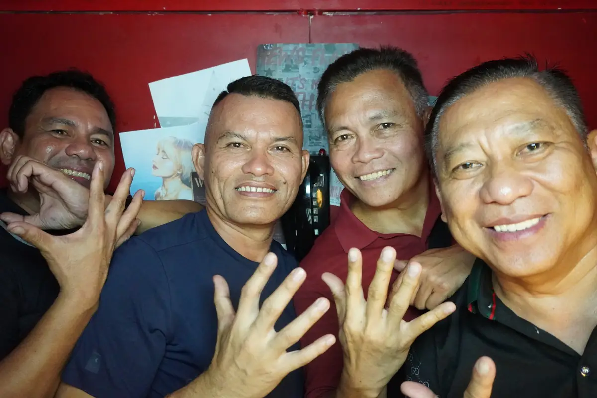 Four friends waving at the camera at a birthday party