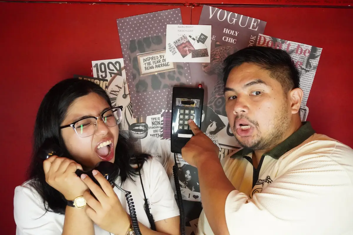 Two friends hamming it up with the booth phone at Pug Street