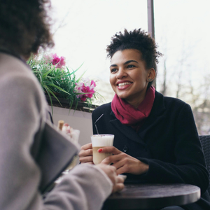 Two professional women in meaningful conversation, supportive mentorship moment, emotional connection