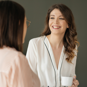 Professional woman smiling and energized at work, collaborative environment, natural light, authentic joy