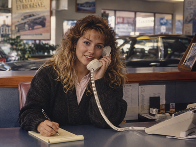 Young woman unexpectedly beginning career in automotive dealership environment Young woman unexpectedly beginning career in automotive dealership environment