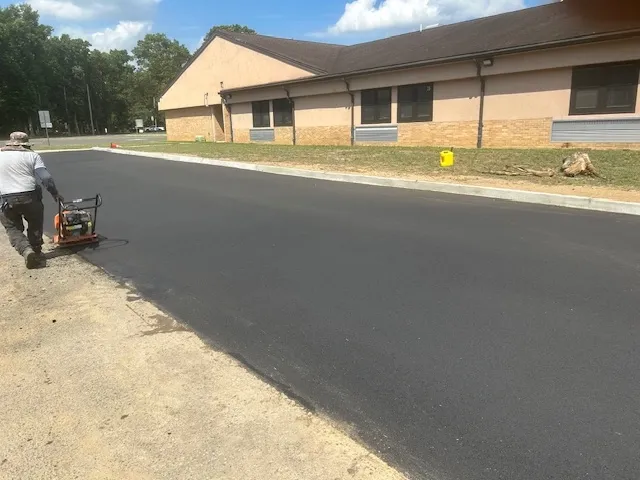 After image of an industrial site where the railroad trench has been filled in with concrete and paved over. The smooth, light-colored concrete surface now covers the previously visible trench, creating a neat and uniform appearance. The area looks clean and well-maintained, indicating the successful completion of the renovation project. Visible sections of construction equipment and safety barriers in the background further emphasize the recently finished work.