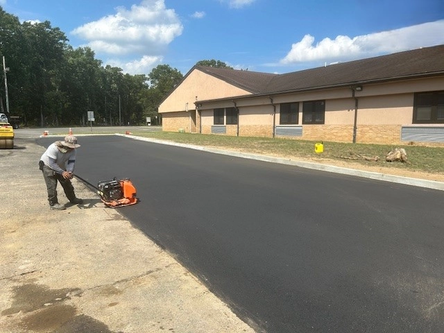 After image of an industrial site where the railroad trench has been filled in with concrete and paved over. The smooth, light-colored concrete surface now covers the previously visible trench, creating a neat and uniform appearance. The area looks clean and well-maintained, indicating the successful completion of the renovation project. Visible sections of construction equipment and safety barriers in the background further emphasize the recently finished work.