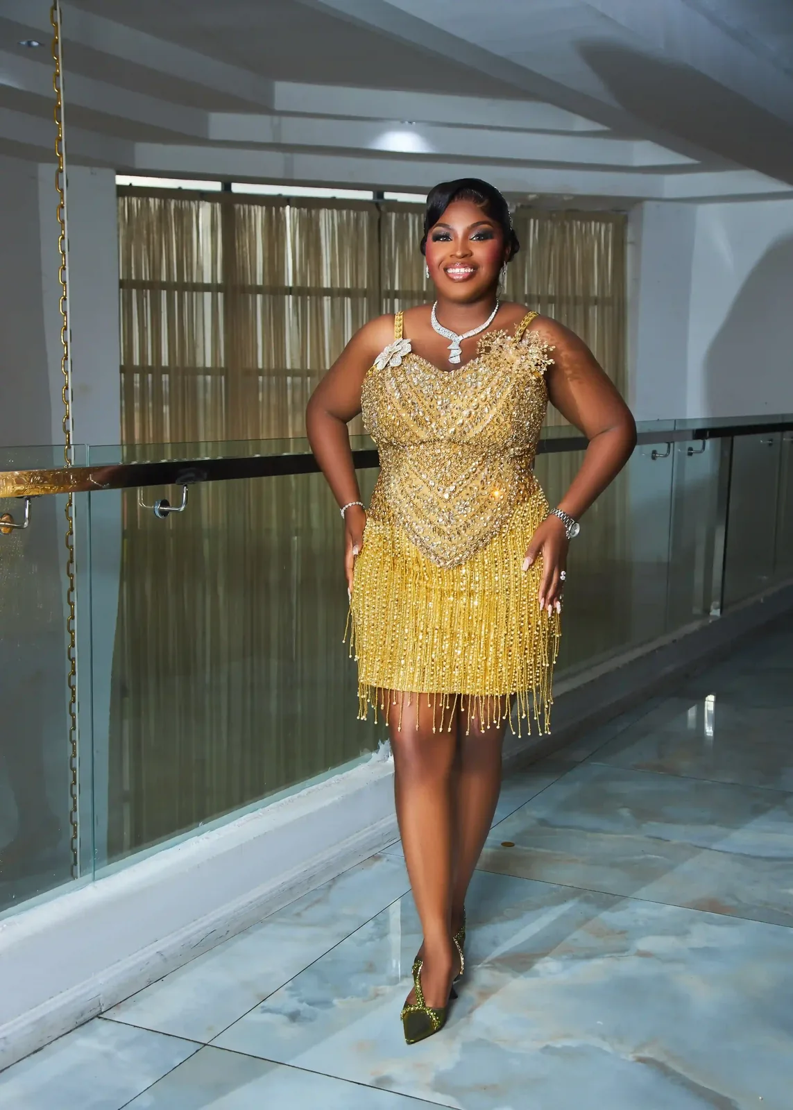 Woman walking indoors in a short gold formal dress