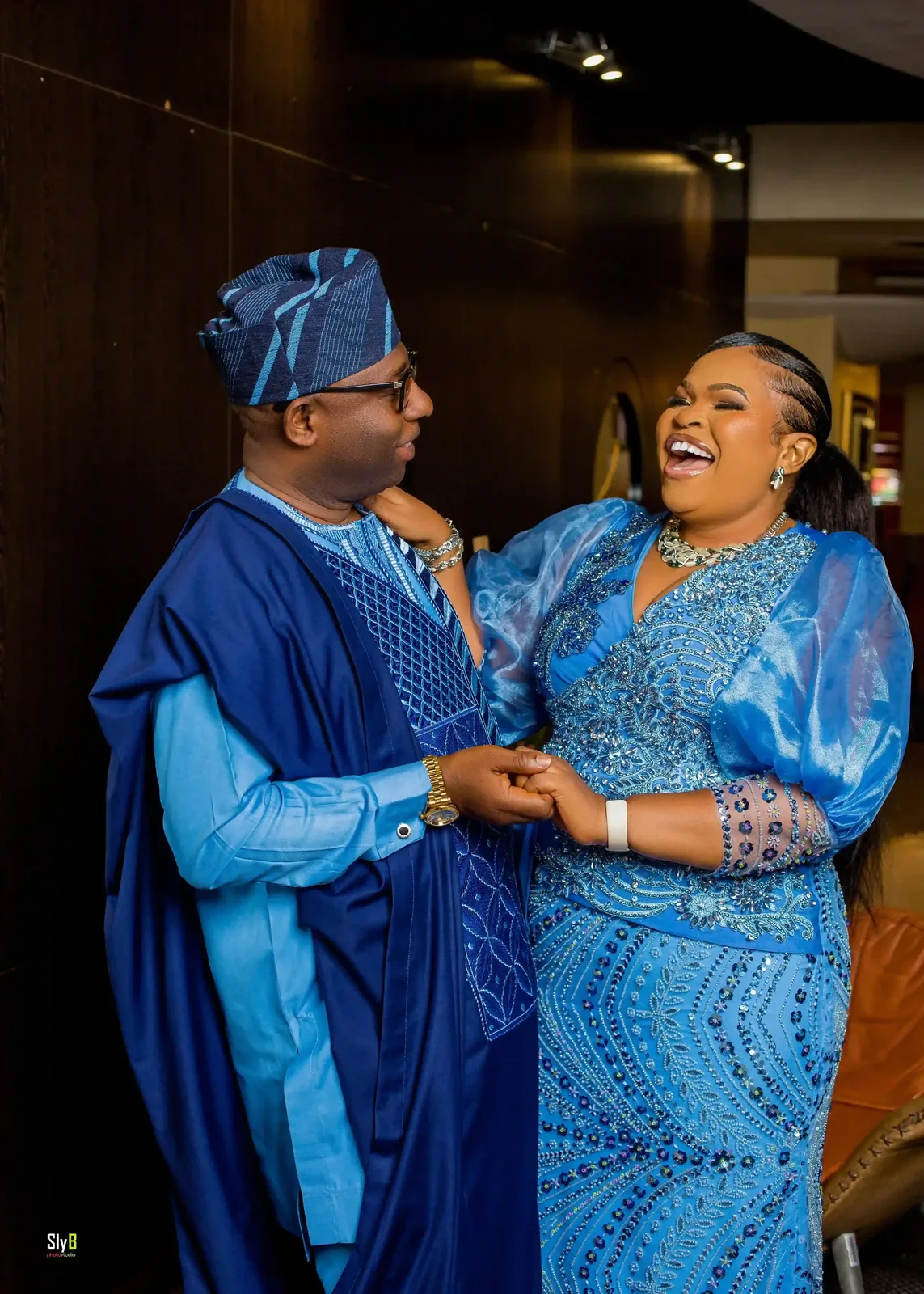 Two people laughing together in matching blue formal attire